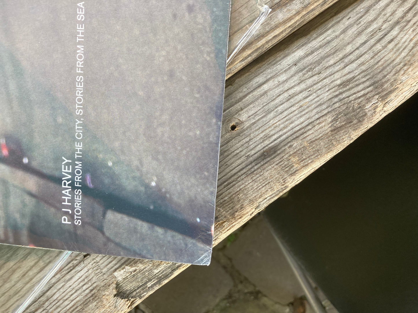 A small crease in the corner of The front of 'PJ Harvey - Stories From the City, Stories From the Sea '