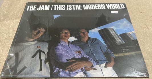 The Jam album cover for 'This is the Modern World' featuring the band members with a cityscape background.